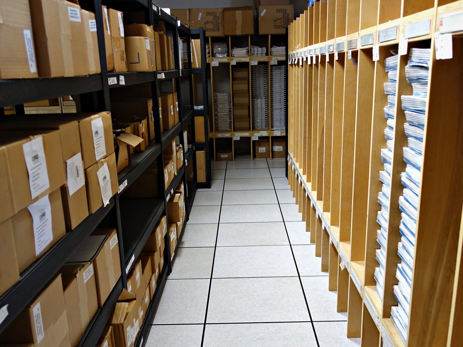 An aisle of customer inventory on racking at Broudy Printing